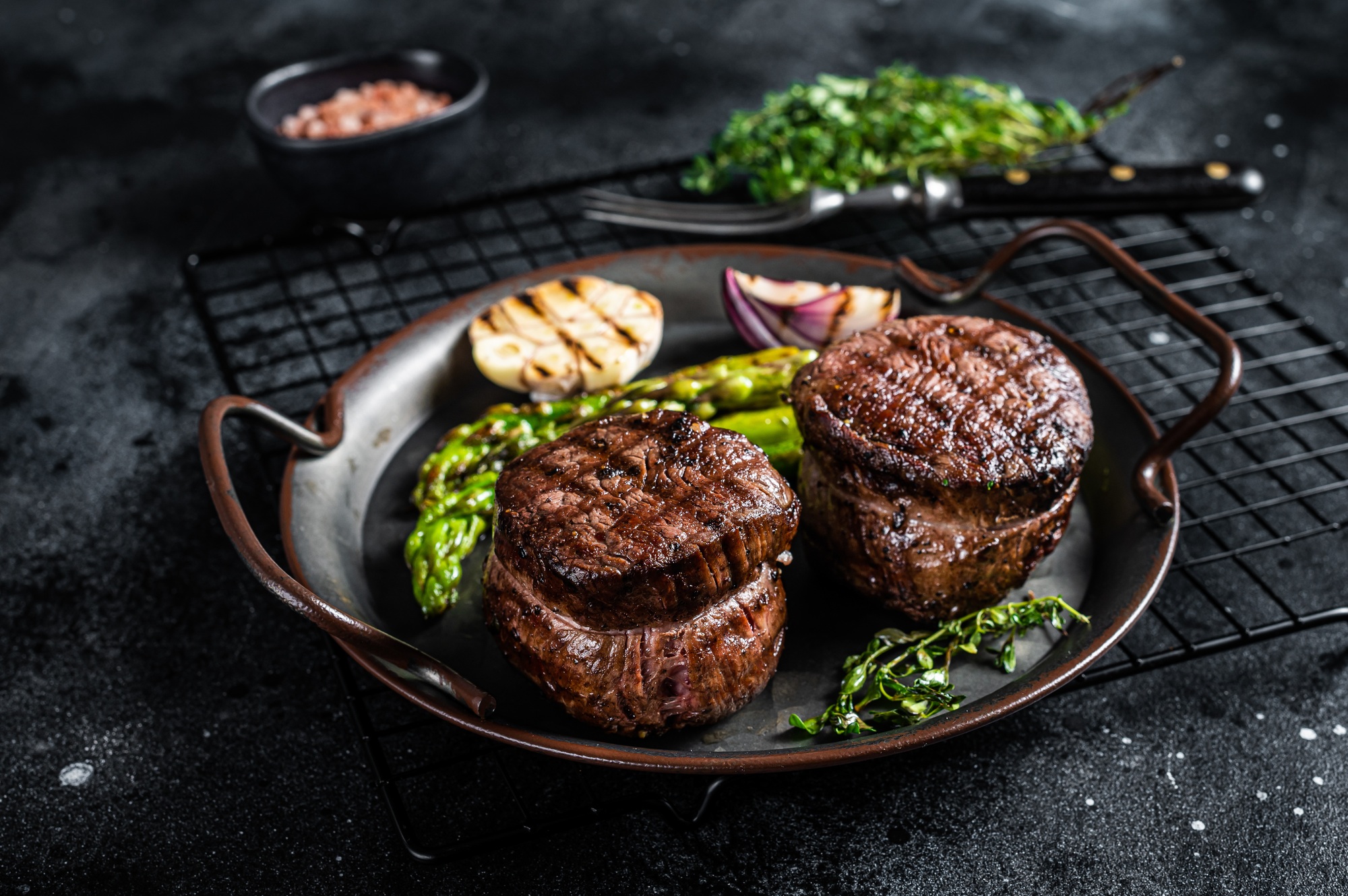 Grilled Fillet Mignon Steak with roasted asparagus. Black background. Top view